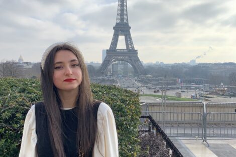 Danielle Kraidin sitting with the Eiffel Tower in the background