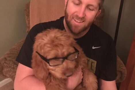Brian Ludrof with his dog, who has glasses on his face