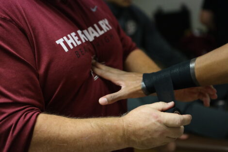 An athletic trainer tapes a player's wrist.