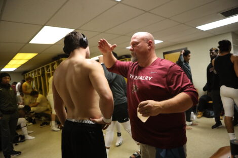 Matt Bayly attends to a football player in the lockerroom.