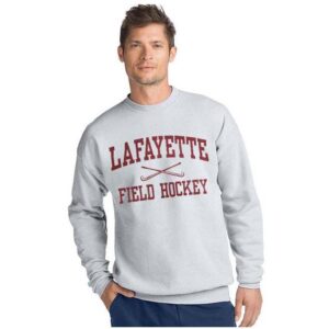 A man wears a Lafayette College field hockey shirt with an illustration of two crossing field hockey sticks under the word Lafayette