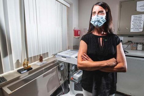 Jodi Schluter inside a Bailey Health Center room stands while wearing a medical mask.