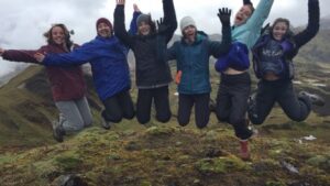 Six Lafayette College students jump with arms raised during a study abroad trip.