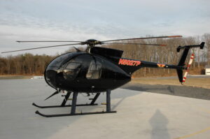 A black Hughes MD500 helicopter
