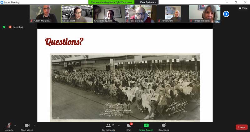 A screen of a Zoom call with participants pictured at the top and the main image being a black-and-white photo of a crowd of students seated at tables in Lafayette's Alumni Gymnasium