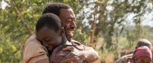 A father embraces his son in a scene from the film The Boy Who Harnessed the Wind.