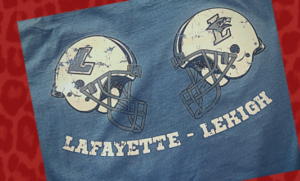 A blue shirt wiith illustrations of vintage Lafayette and Lehigh football helmets