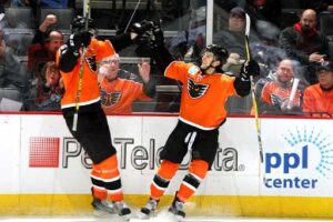 Two players on the Lehigh Valley Phantoms hockey team celebrate after a goal.