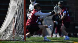 Goalie Ryan Ness makes a save in a men's lacrosse game.