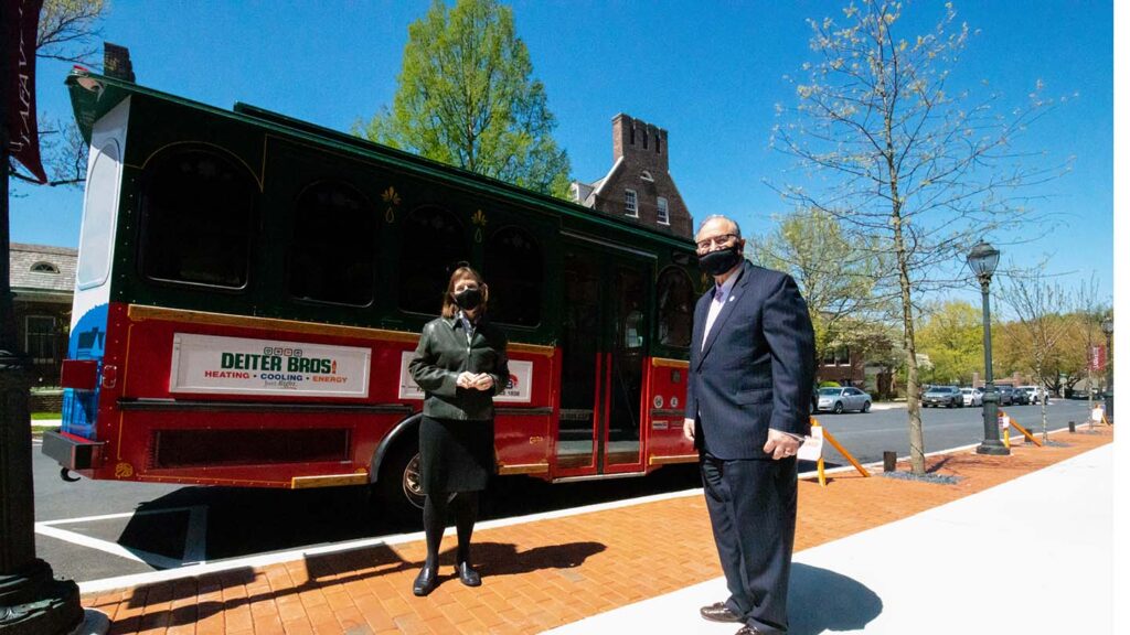 President Byerly and Mayor Panto stand outside in masks in front of the Easton Trolley