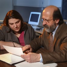 Professor George Panichas and student Amanda Roth look at a paper together.
