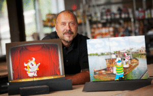 Joe Swarctz with two different children's cartoon drawings of his