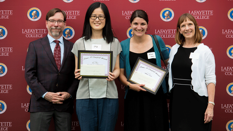 Ying “Joy” Zhou and Allison Lewis hold their awards while flanked by Provost John Meier and President Alison Byerly in front of a Lafayette-branded backdrop at Fisher Stadium.