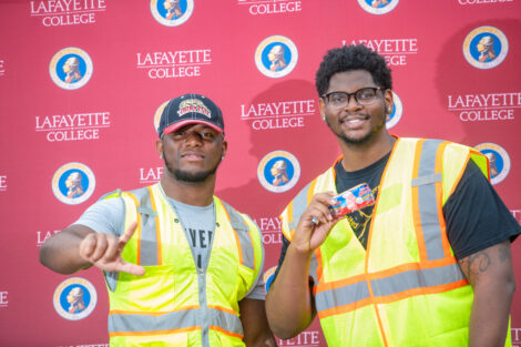 Two male students pose in front of the Lafayette-branded backdrop at the conclusion of the faculty-staff awards event at Fisher Stadium
