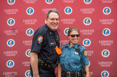 Two Public Safety officers in uniform pose in front of the Lafayette-branded backdrop at the conclusion of the faculty-staff awards event at Fisher Stadium
