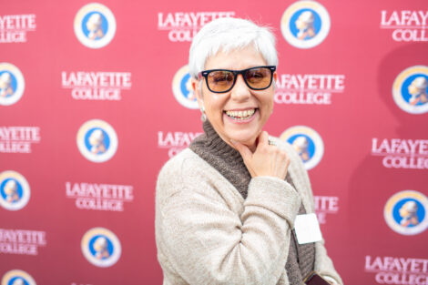 A female employee poses in front of the Lafayette-branded backdrop at the conclusion of the faculty-staff awards event at Fisher Stadium