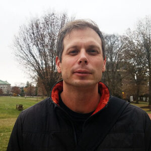 Dave Sunderlin on the Quad with Pardee Hall behind him