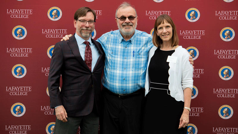 Ilan Peleg flanked by Provost John Meier and President Alison Byerly in front of a Lafayette-branded backdrop at Fisher Stadium.