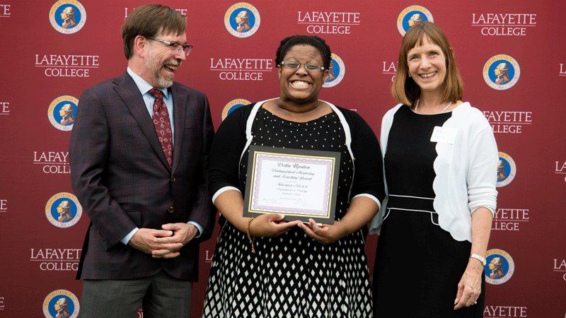 Khadijah Mitchell holds her award while flanked by Provost John Meier and President Alison Byerly.