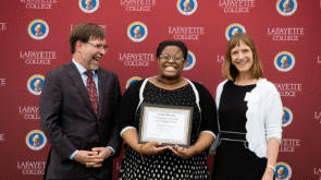 Khadijah Mitchell holds her award while flanked by Provost John Meier and President Alison Byerly.