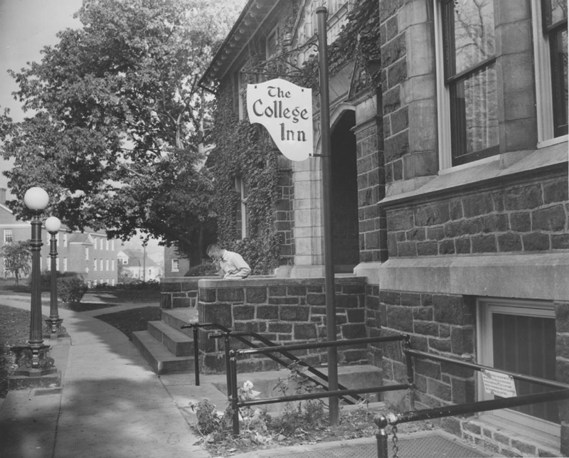 A black-and-white photo of Hogg Hall with a sign for The College Inn outside
