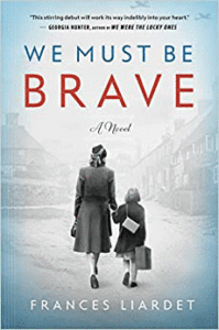 The cover of the book We Must be Brave, An image of a woman holding hands with a child as they walk a city street in World War II England