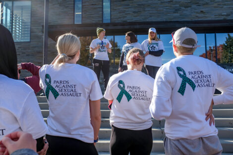 Supporters of Pards Against Sexual Assault listen before the start of the Take Back the Night 5K, Nov. 2021