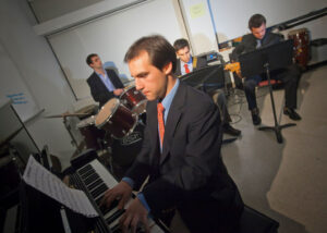 Four student musicians dressed formally perform in a jazz combo.