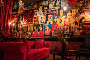 A portion of the interior of Maxim's 22, with a red couch and a wall covered with French posters