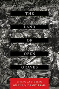 The cover of the book The Land of Open Graves, with a black and white photo of what appears to be bags