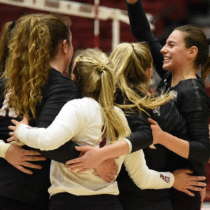 Lafayette volleyball players hug on the court after winning a set.