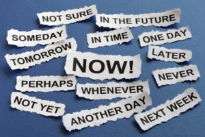 An image of words related to procrastination, including now, not yet, never, another day, later