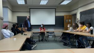 Simone sits while Prof. Phillips stands and introduces her