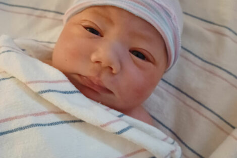 Newborn baby Sophia Biener under a blanket and wearing a cap