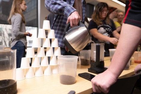 Coffee cups are stacked, and coffee is poured during Professor Joseph Woo’s FYS143 Coffee Showcase.