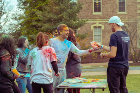 Students hand out colored powder to be thrown during Holi Fest 2023.