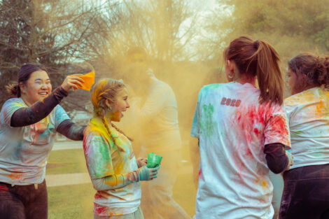 Students throw colorful powder on the Quad during Holi Fest.