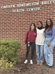 Narena Nerahoo, Fathima Yumna Hussain, and Olivia Bamford, student writers for Bailey Health Center, are pictured in front of the health center.