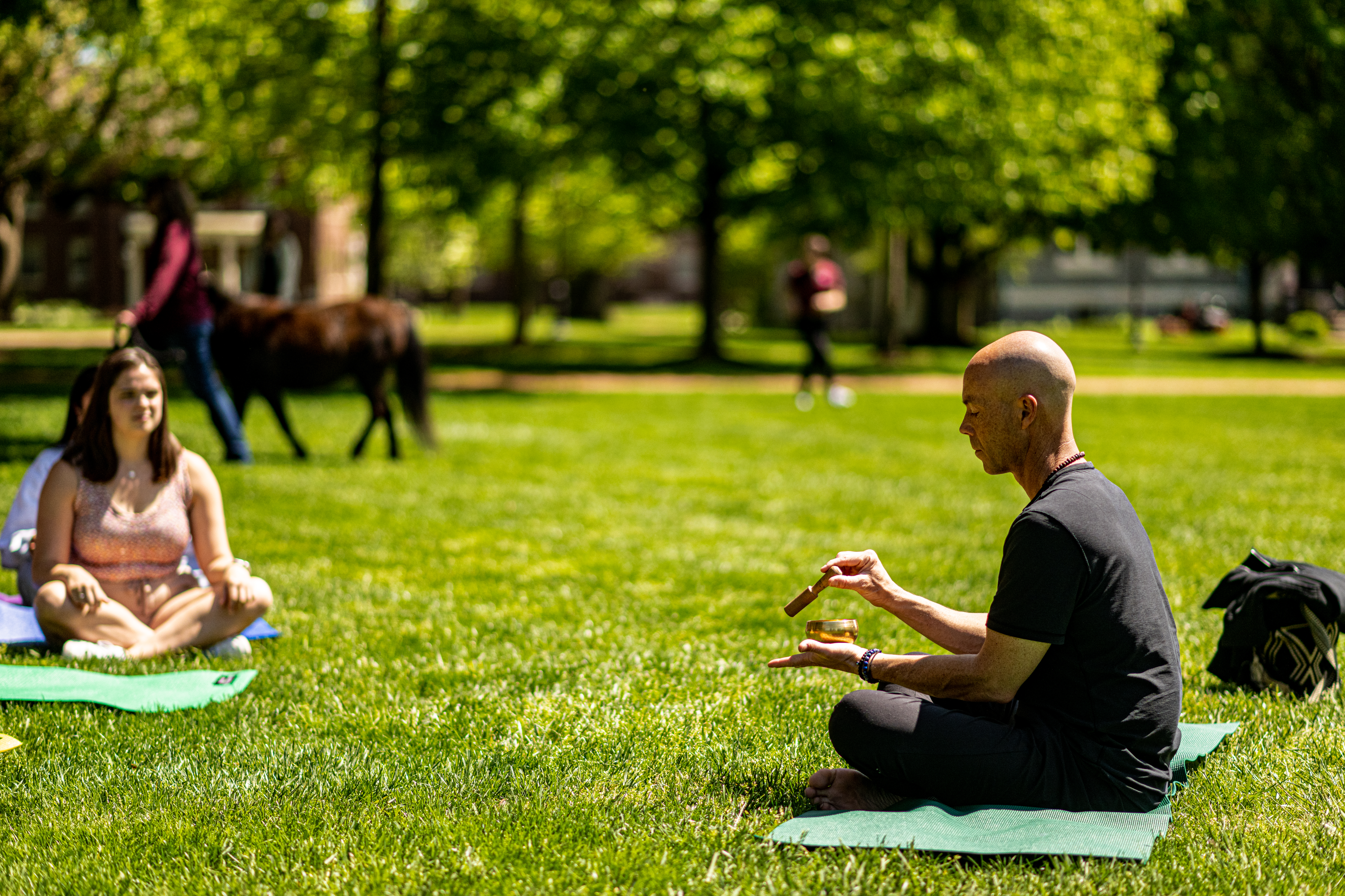 An instructor leads students through outdoor mindfulness event on Quad.