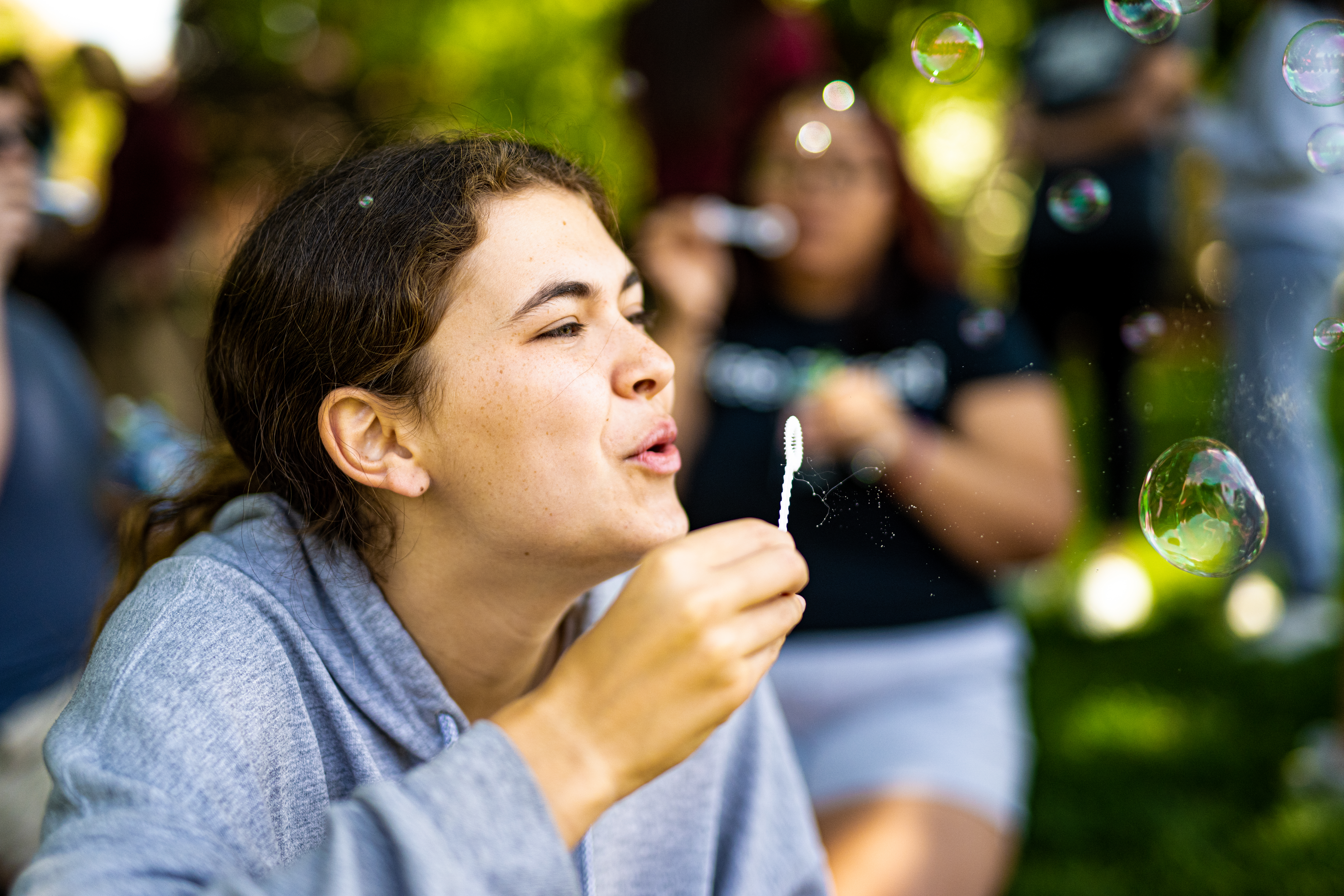 A student blows bubbles during Bubble Hunt, May 2023
