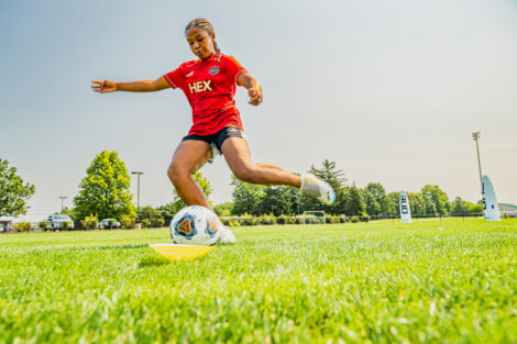 A girl shoots a soccer ball into a net on the new Gummeson Grounds field.