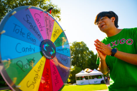 A student spins a prize wheel during Latinx Fest hoping he wins a prize.