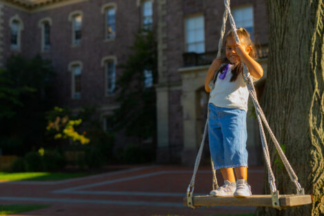 A little girl swings on the Quad during Latinx Fest.