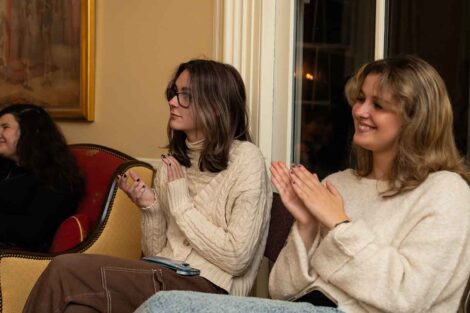 Students clap as others perform poetry during a Poetry Slam at the President's House.