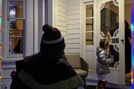 The Las Posadas group arrives at the porch of the President's House and a little girl dressed as an angel knocks on the door.