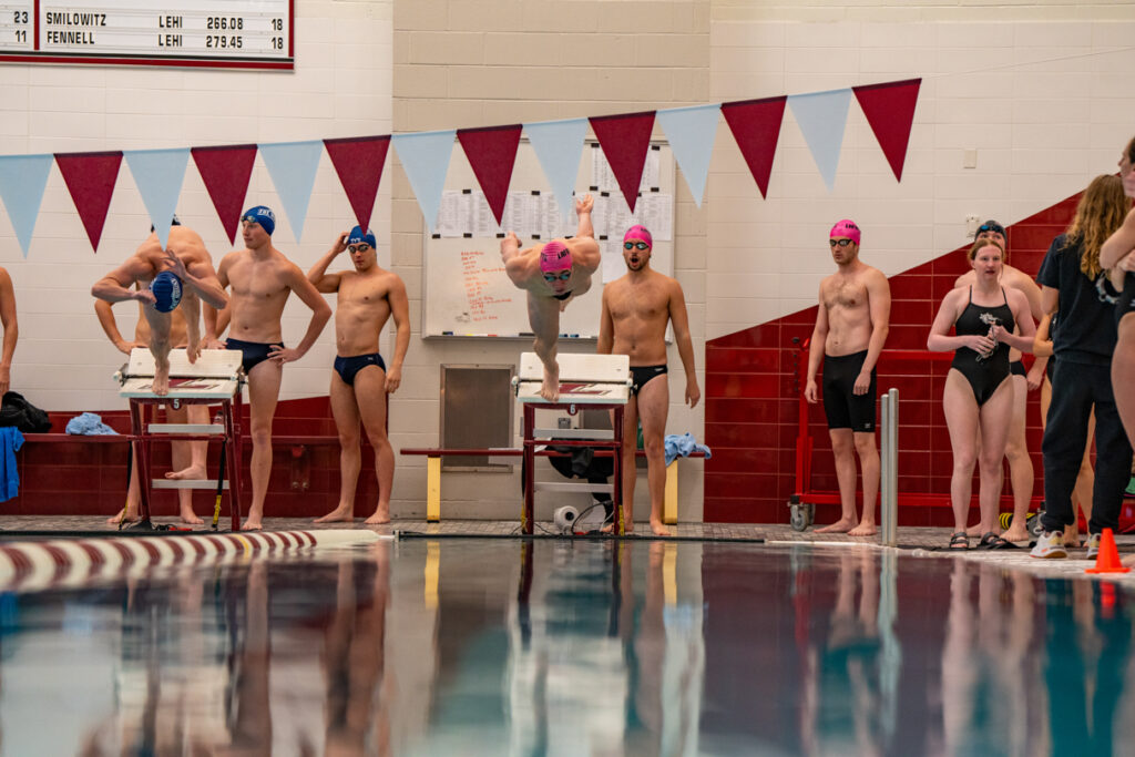 A Lafayette student athlete dives off the starting platform into his individual pool lane.
