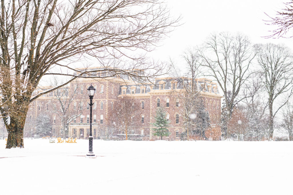 The Quad and Pardee Hall are covered in snow as more snow falls from the sky. 