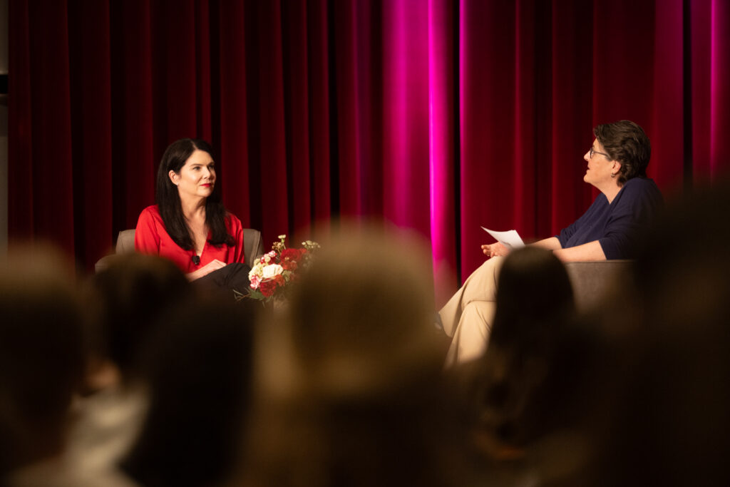 Lauren Graham, star of the Gilmore Girls and Parenthood, is positioned on the left side of the frame across from professor Mary Armstrong. An audience can be seen in the foreground of the image.