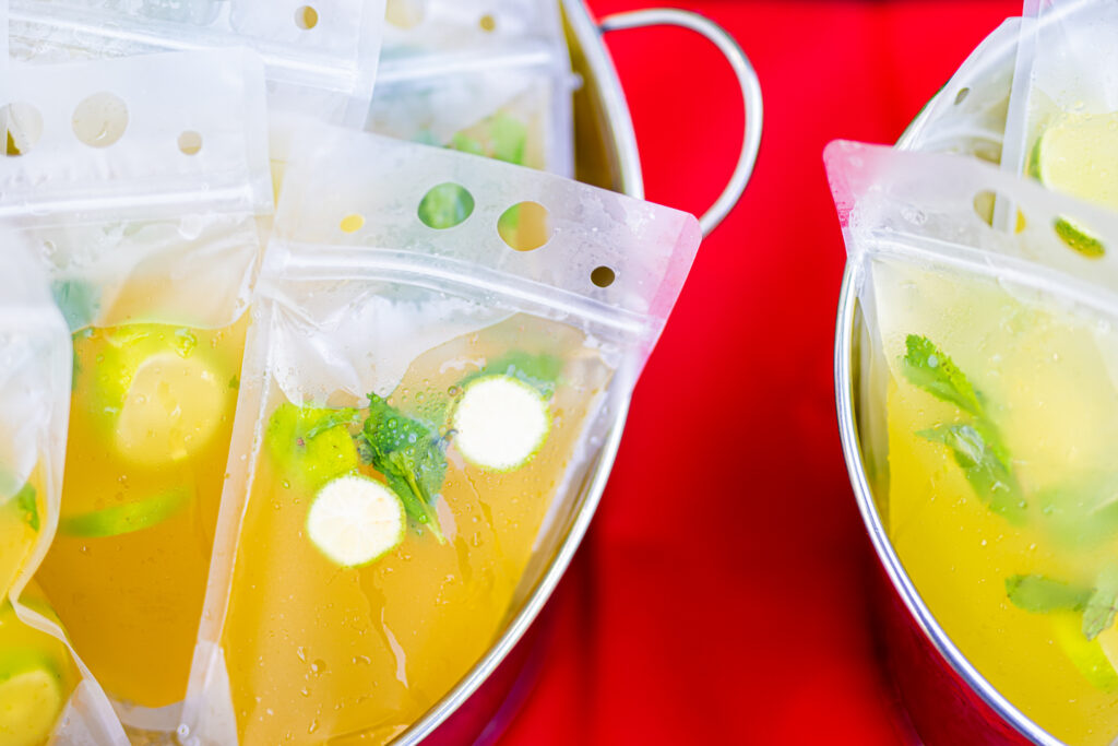 Close up of drink pouches in an ice bucket collecting condensation. 