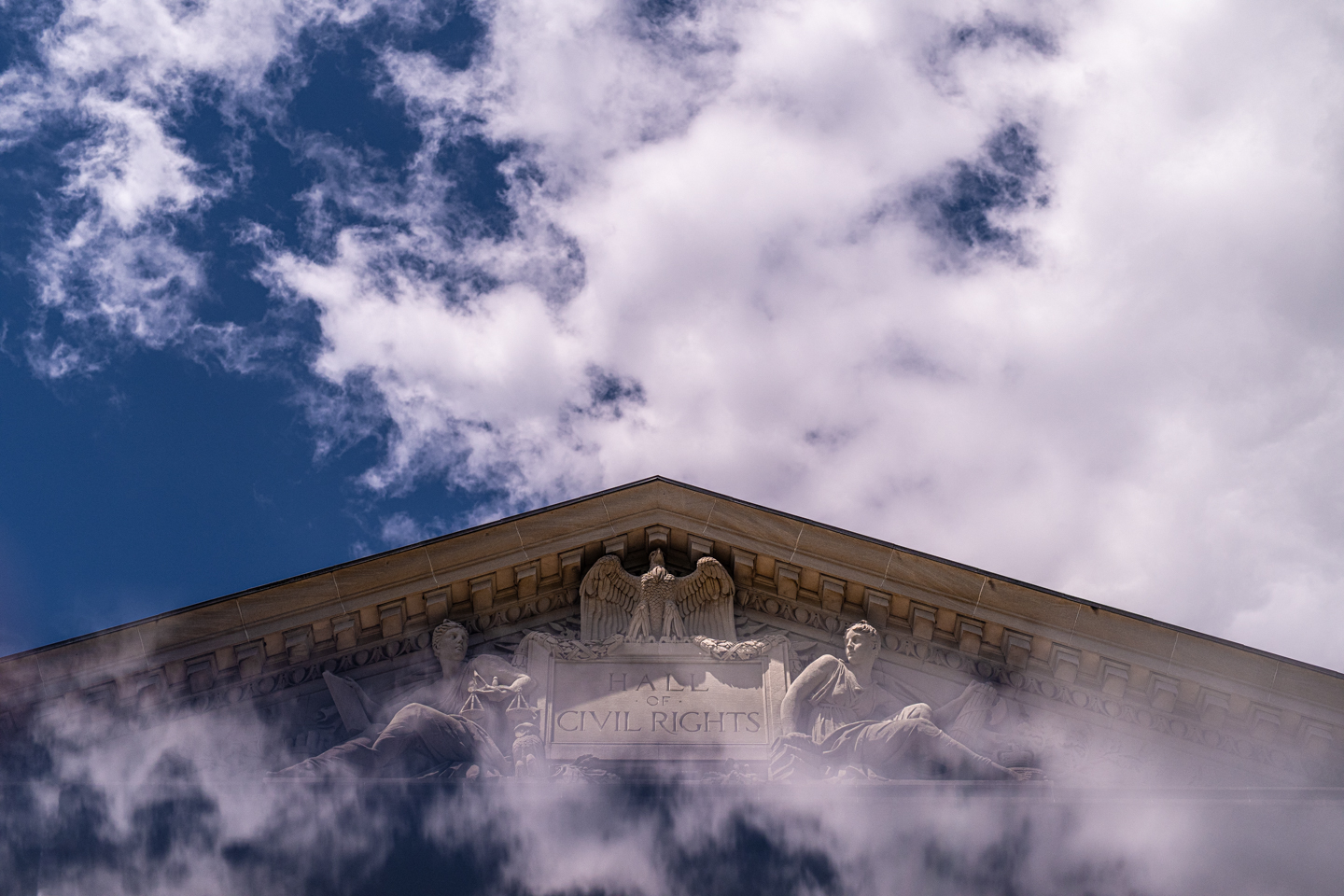 Clouds are reflected on the base of the Roman pediment of the Kirby Hall of Civil Rights. 